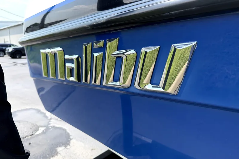 Slide: The Image of Chrome "Malibu" logo on a blue 2008 iRide boat. - 10