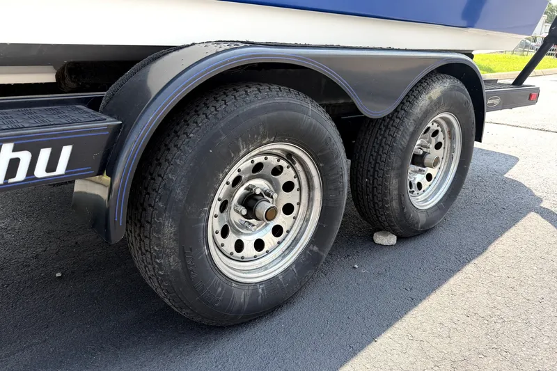 Slide: The Image of Trailer wheels of a 2008 Malibu iRide boat on asphalt pavement. - 43