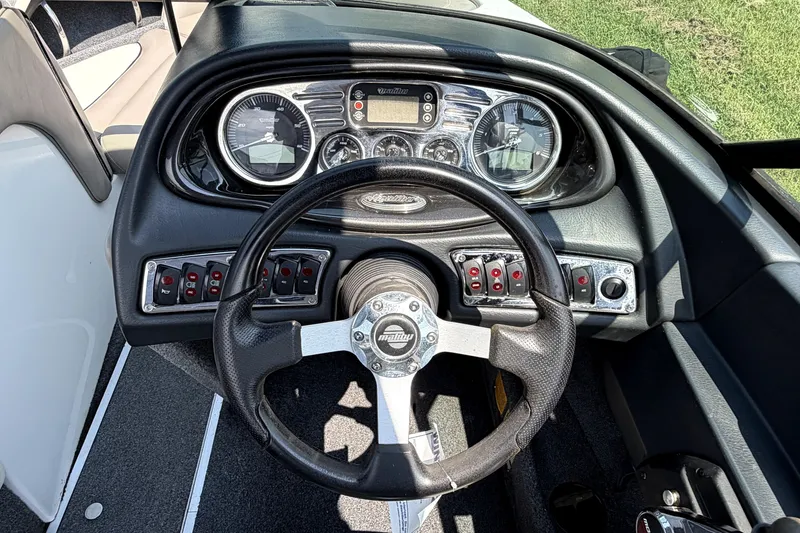 Slide: The Image of Dashboard of a 2008 Malibu iRide boat with steering wheel and control panel. - 24