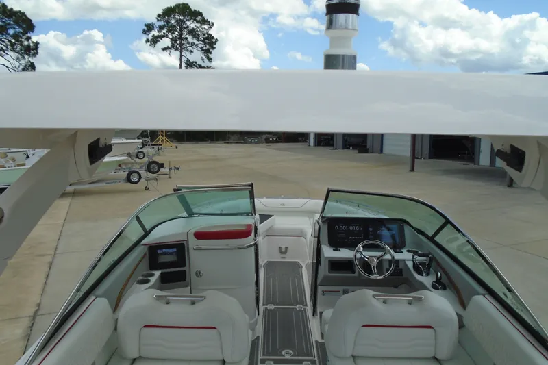 Slide: The Image of 2024 Regal LX9 boat interior with modern dashboard and seating, docked under clear skies. - 23
