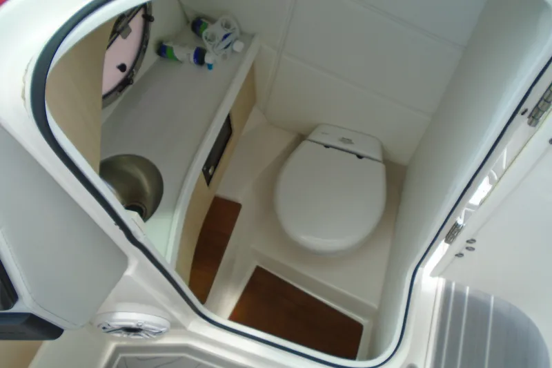 Slide: The Image of 2024 Regal LX9 boat bathroom with toilet, sink, and storage shelves. - 15