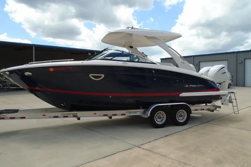 Slide: The Image of 2024 Regal LX9 boat on trailer, parked outdoors under cloudy sky. - 4