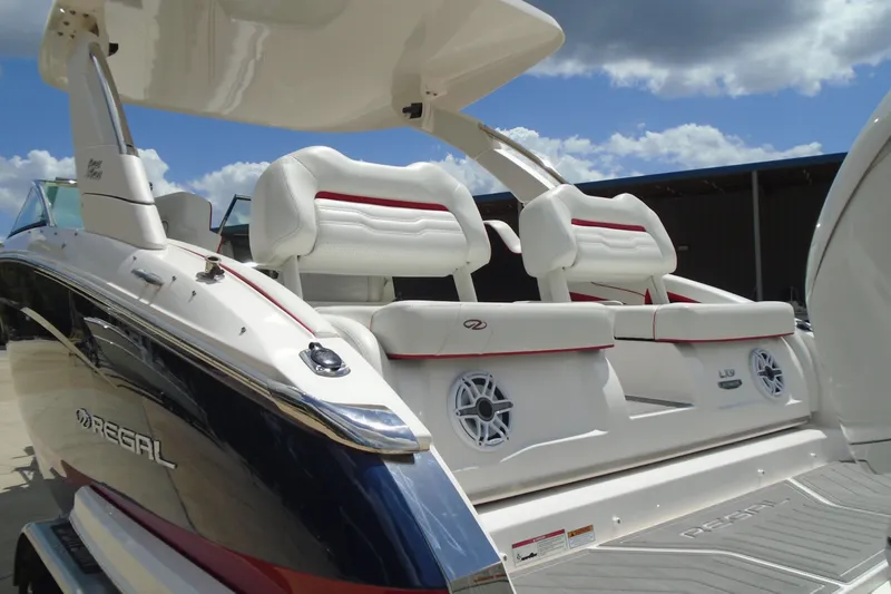 Slide: The Image of 2024 Regal LX9 boat with luxurious white seating and sleek design under a blue sky. - 31