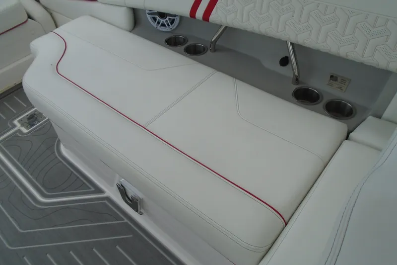 Slide: The Image of 2024 Regal LX9 boat interior with white seating, red accents, and cup holders. - 20