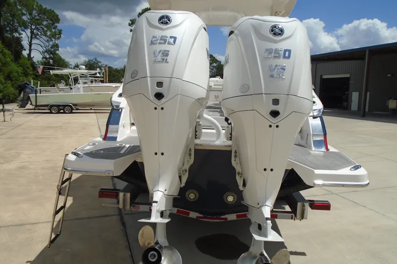 Slide: The Image of 2024 Regal LX9 boat with dual Yamaha 250 V6 outboard engines in a marina setting. - 6