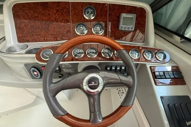 Slide: The Image of Dashboard of a 2005 Formula 370 Super Sport boat with wood accents and gauges. - 15