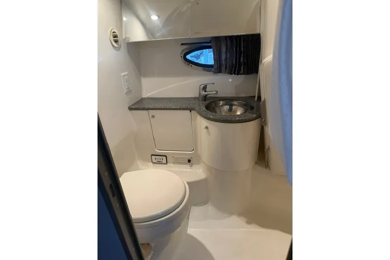 Slide: The Image of Compact bathroom in a 2005 Formula 370 Super Sport boat, featuring a toilet and sink. - 13