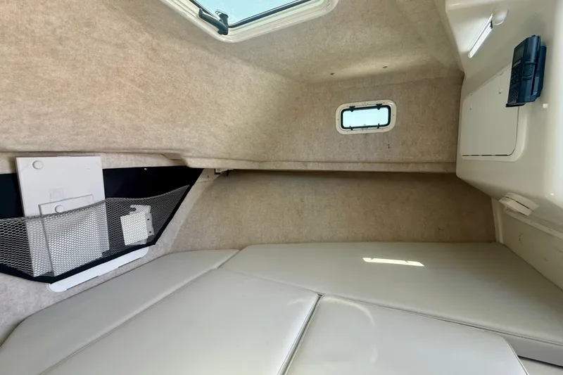 Slide: The Image of Interior cabin of 2022 Parker 2520 XLD Sport Cabin boat, featuring cozy seating and storage. - 13