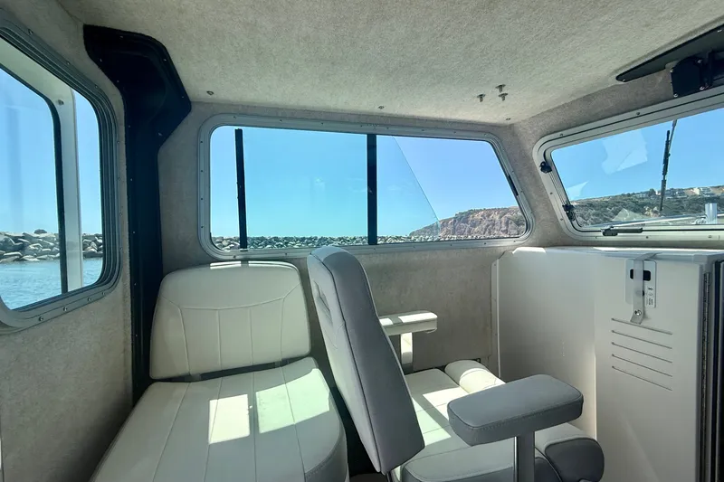 Slide: The Image of Interior of 2022 Parker 2520 XLD Sport Cabin with coastal view through windows. - 14