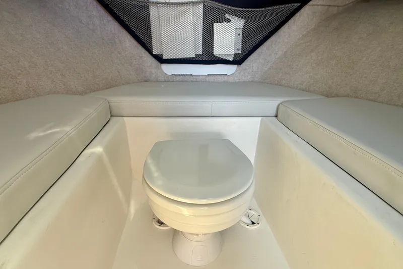 Slide: The Image of Interior of 2022 Parker 2520 XLD Sport Cabin with marine toilet and cushioned seating. - 10
