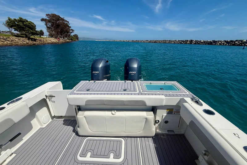 Slide: The Image of 2022 Parker 2520 XLD Sport Cabin boat with dual engines on calm blue water. - 18