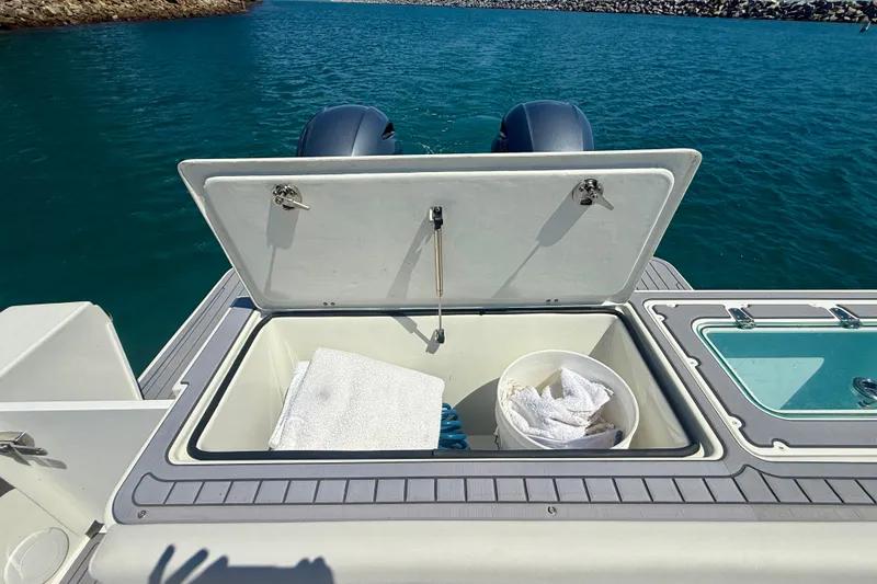 Slide: The Image of 2022 Parker 2520 XLD Sport Cabin boat with open storage compartment and ocean view. - 19