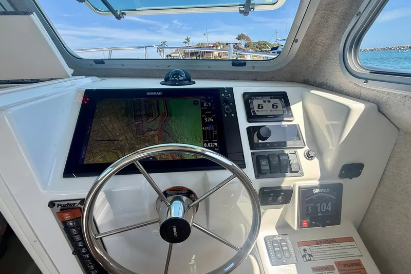Slide: The Image of 2022 Parker 2520 XLD Sport Cabin helm with Simrad navigation system and steering wheel. - 41