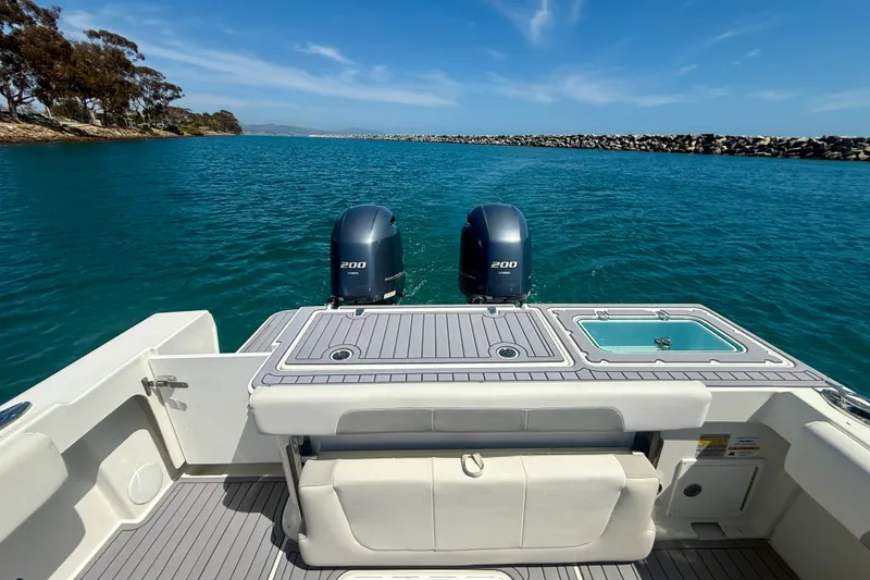 Slide: The Image of 2022 Parker 2520 XLD Sport Cabin boat with dual 200 horsepower engines on blue water. - 16