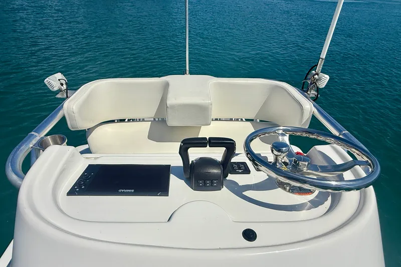 Slide: The Image of Helm of 2022 Parker 2520 XLD Sport Cabin boat on calm blue water. - 28