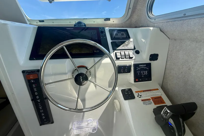 Slide: The Image of Interior helm of 2022 Parker 2520 XLD Sport Cabin with steering wheel and navigation controls. - 36