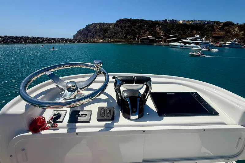 Slide: The Image of Helm of 2022 Parker 2520 XLD Sport Cabin overlooking scenic marina and cliffs. - 29