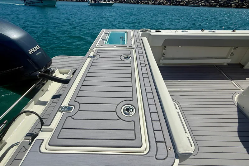 Slide: The Image of 2022 Parker 2520 XLD Sport Cabin boat deck with Yamaha 200 engine, docked on clear water. - 21