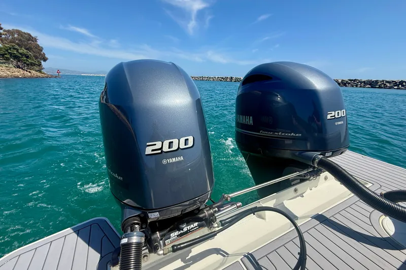 Slide: The Image of Twin Yamaha 200 engines on a 2022 Parker 2520 XLD Sport Cabin boat in clear waters. - 20