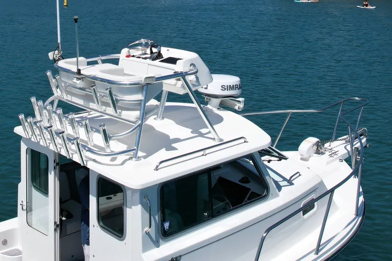 Slide: The Image of 2022 Parker 2520 XLD Sport Cabin boat on water, featuring upper deck and radar equipment. - 7