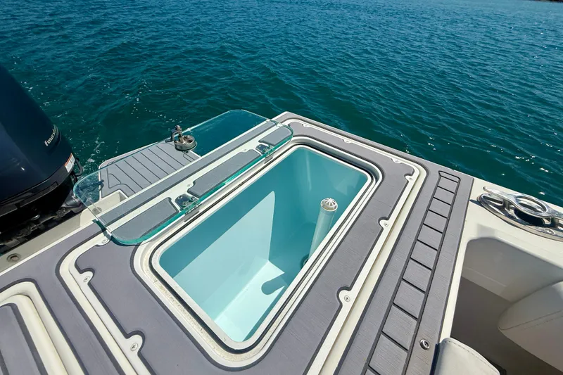 Slide: The Image of 2022 Parker 2520 XLD Sport Cabin boat with open livewell on calm water. - 17