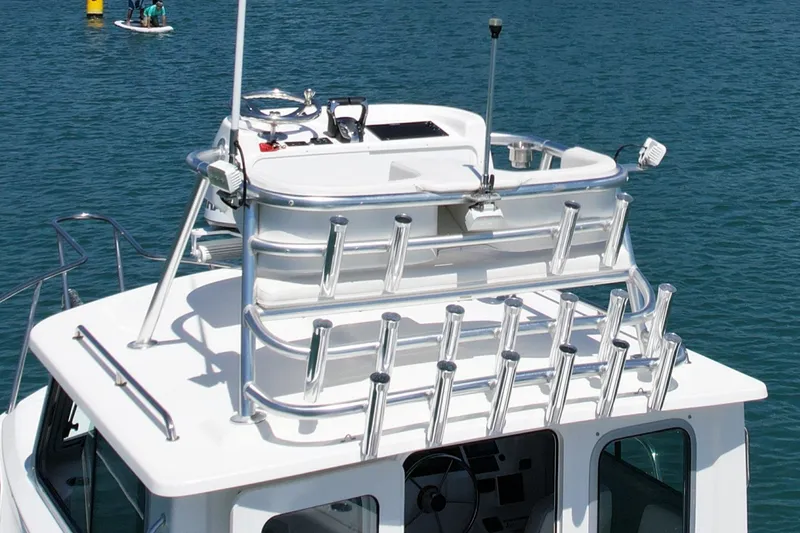 Slide: The Image of 2022 Parker 2520 XLD Sport Cabin boat with rooftop rod holders on a sunny day. - 6