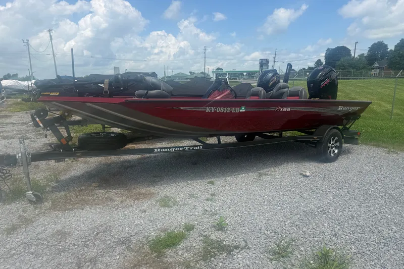 Slide: The Image of 2018 Ranger RT188 boat on trailer, parked on gravel under a cloudy sky. - 3