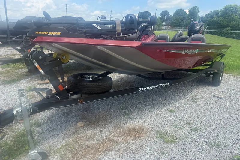 Slide: The Image of 2018 Ranger RT188 boat on trailer, featuring Minn Kota Maxxum motor, parked on gravel. - 4