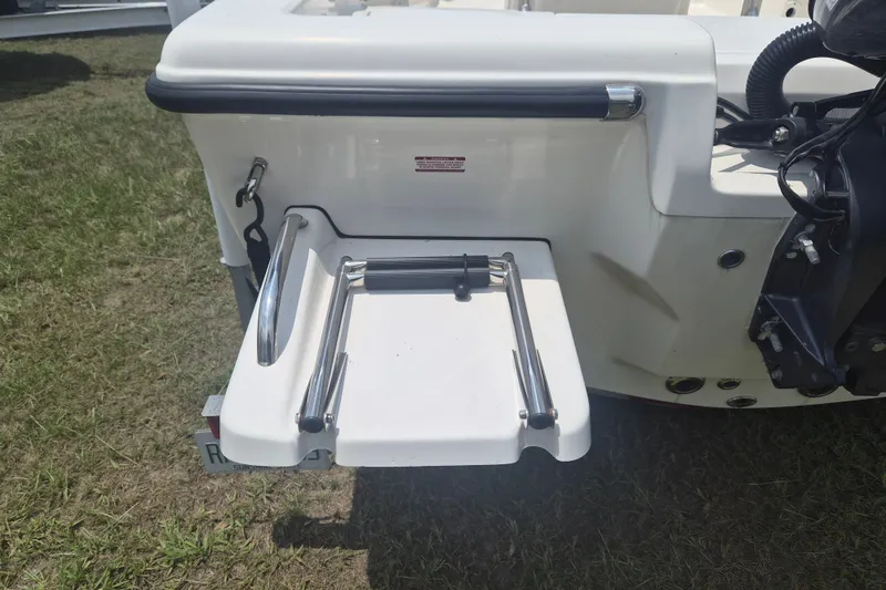 Slide: The Image of 2024 Key West 179 FS boat with foldable swim platform ladder on grass. - 4