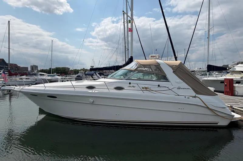 Slide: The Image of 1999 Sea Ray Sundancer 330 yacht docked at marina under cloudy sky. - 1