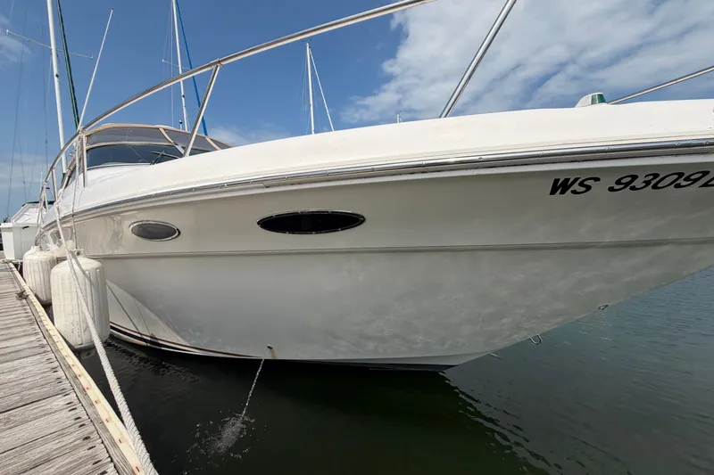 Slide: The Image of 1999 Sea Ray Sundancer 330 yacht docked, showcasing sleek design and white exterior. - 8
