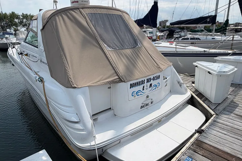 Slide: The Image of 1999 Sea Ray Sundancer 330 docked at marina, featuring tan canvas cover. - 3