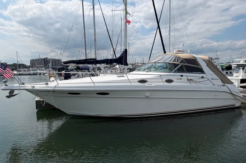 Slide: The Image of 1999 Sea Ray Sundancer 330 yacht docked in marina, under cloudy sky. - 0