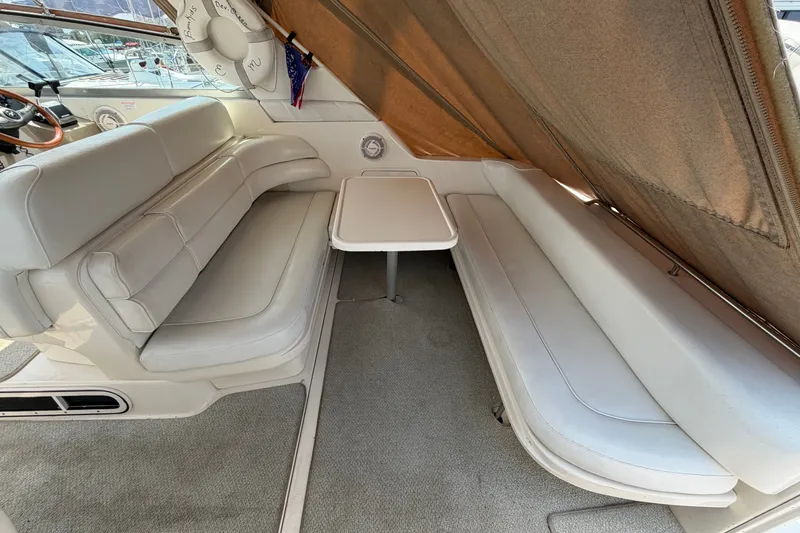 Slide: The Image of 1999 Sea Ray Sundancer 330 interior with white seating and table, showcasing luxury boat design. - 12
