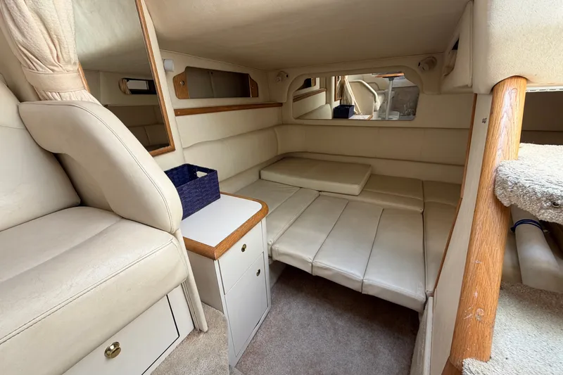 Slide: The Image of Interior cabin of a 1999 Sea Ray Sundancer 330, featuring beige upholstery and compact design. - 33