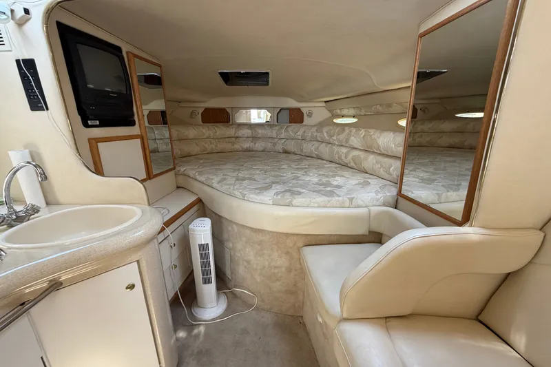 Slide: The Image of 1999 Sea Ray Sundancer 330 cabin interior with bed, sink, and seating area. - 26