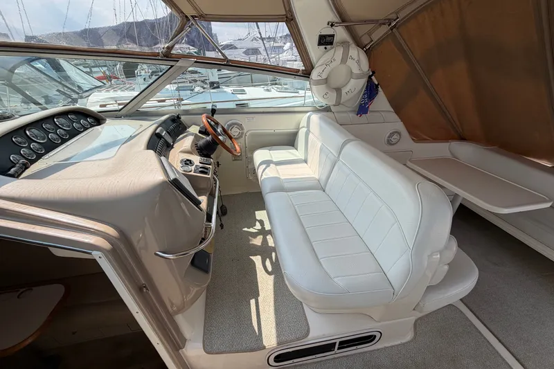 Slide: The Image of 1999 Sea Ray Sundancer 330 cockpit with white seating, steering wheel, and control panel. - 16