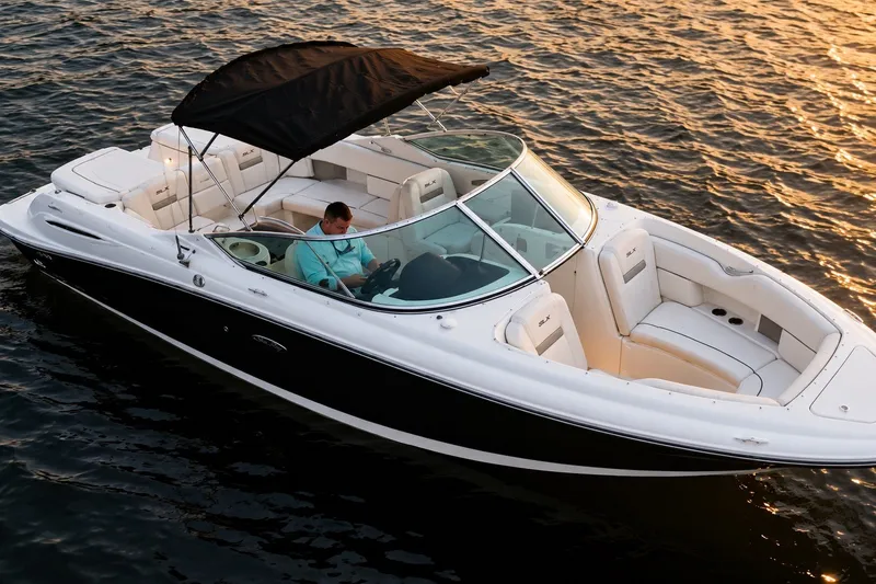 Slide: The Image of 2006 Sea Ray 270 SLX boat cruising on water at sunset with canopy open. - 3