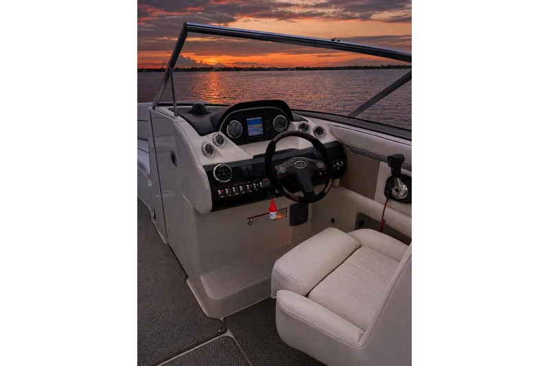Slide: The Image of Cockpit of 2006 Sea Ray 270 SLX boat at sunset, featuring steering wheel and controls. - 43