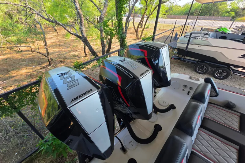 Slide: The Image of 2024 Fountain 38 SC boat with three Mercury outboard engines in a wooded area. - 19
