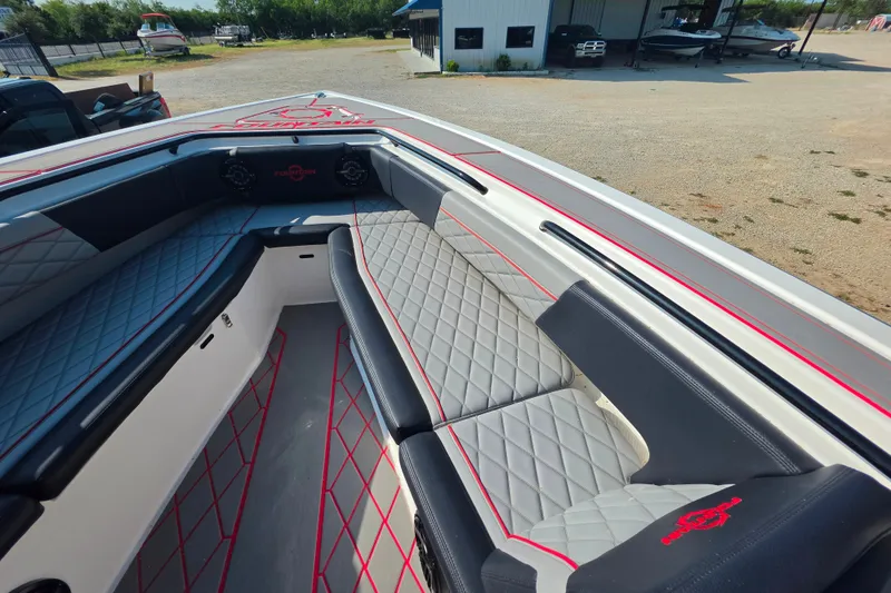 Slide: The Image of 2024 Fountain 38 SC boat interior with diamond-stitched seating and red accents. - 13