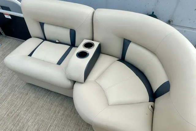 Slide: The Image of 2017 Landau Island Breeze 212 Cruise boat seating with cup holders, featuring beige and blue upholstery. - 6
