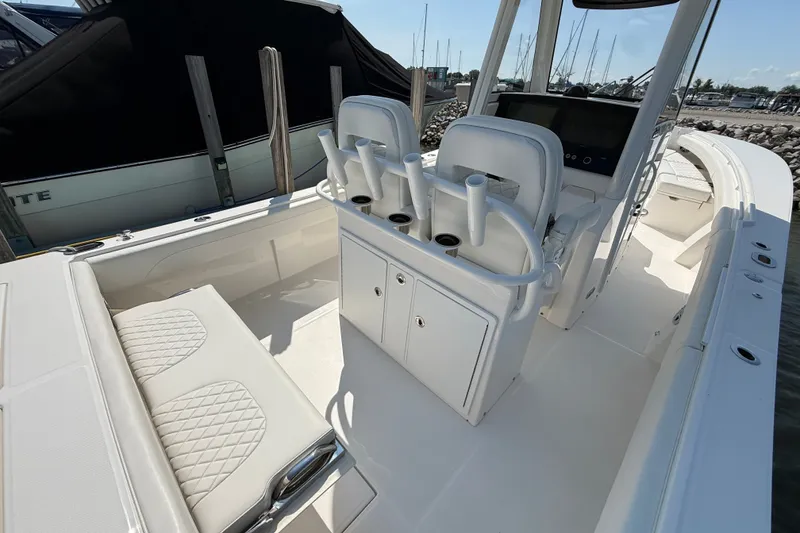 Slide: The Image of 2024 Regulator 28 boat interior with seating and helm station, docked at marina. - 18