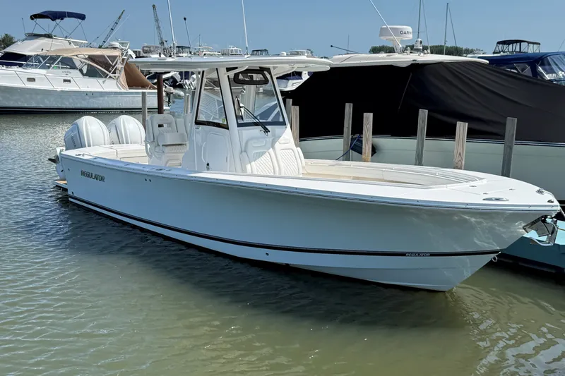 The Image of 2024 Regulator 28 boat docked in marina, featuring sleek design and twin engines. - 0