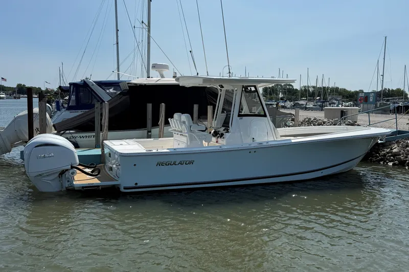 Slide: The Image of 2024 Regulator 28 boat docked in marina, featuring sleek design and powerful outboard engine. - 2