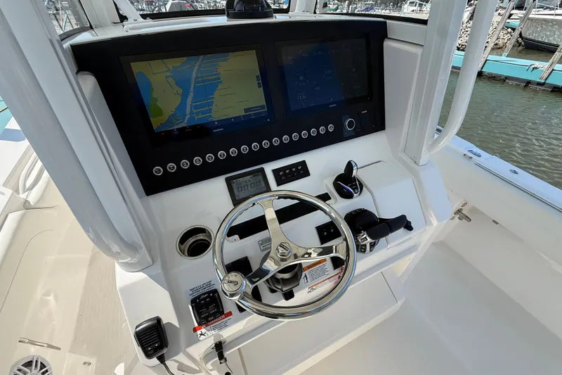 Slide: The Image of 2024 Regulator 28 boat dashboard with navigation screens and steering wheel. - 13