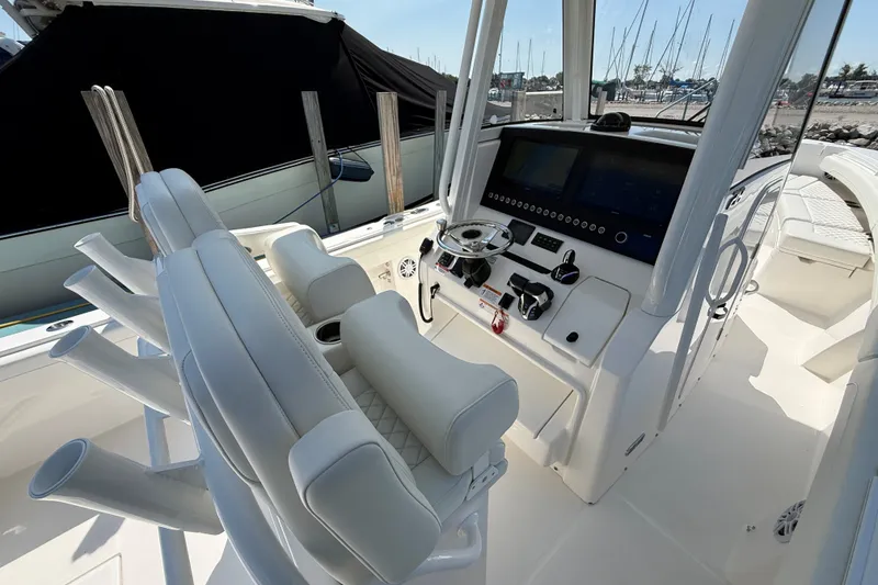 Slide: The Image of 2024 Regulator 28 boat cockpit with modern controls and seating, docked at marina. - 11