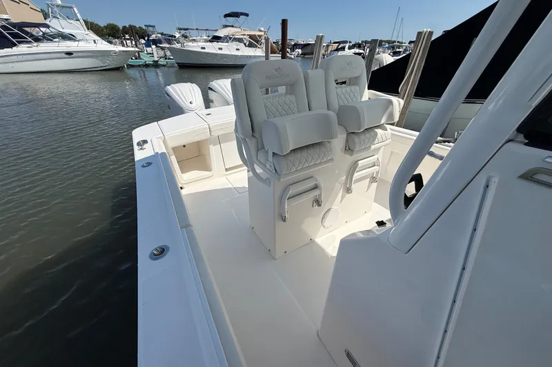 Slide: The Image of 2024 Regulator 28 boat interior with luxurious seating, docked at a marina. - 10