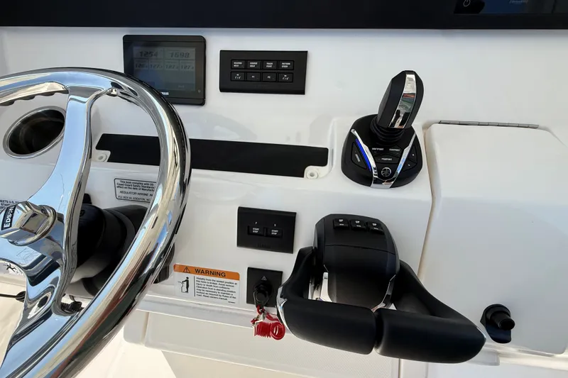 Slide: The Image of 2024 Regulator 28 boat dashboard with steering wheel and control panel. - 15