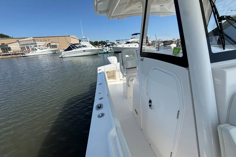 Slide: The Image of 2024 Regulator 28 boat docked at marina, showcasing sleek design and spacious deck. - 9